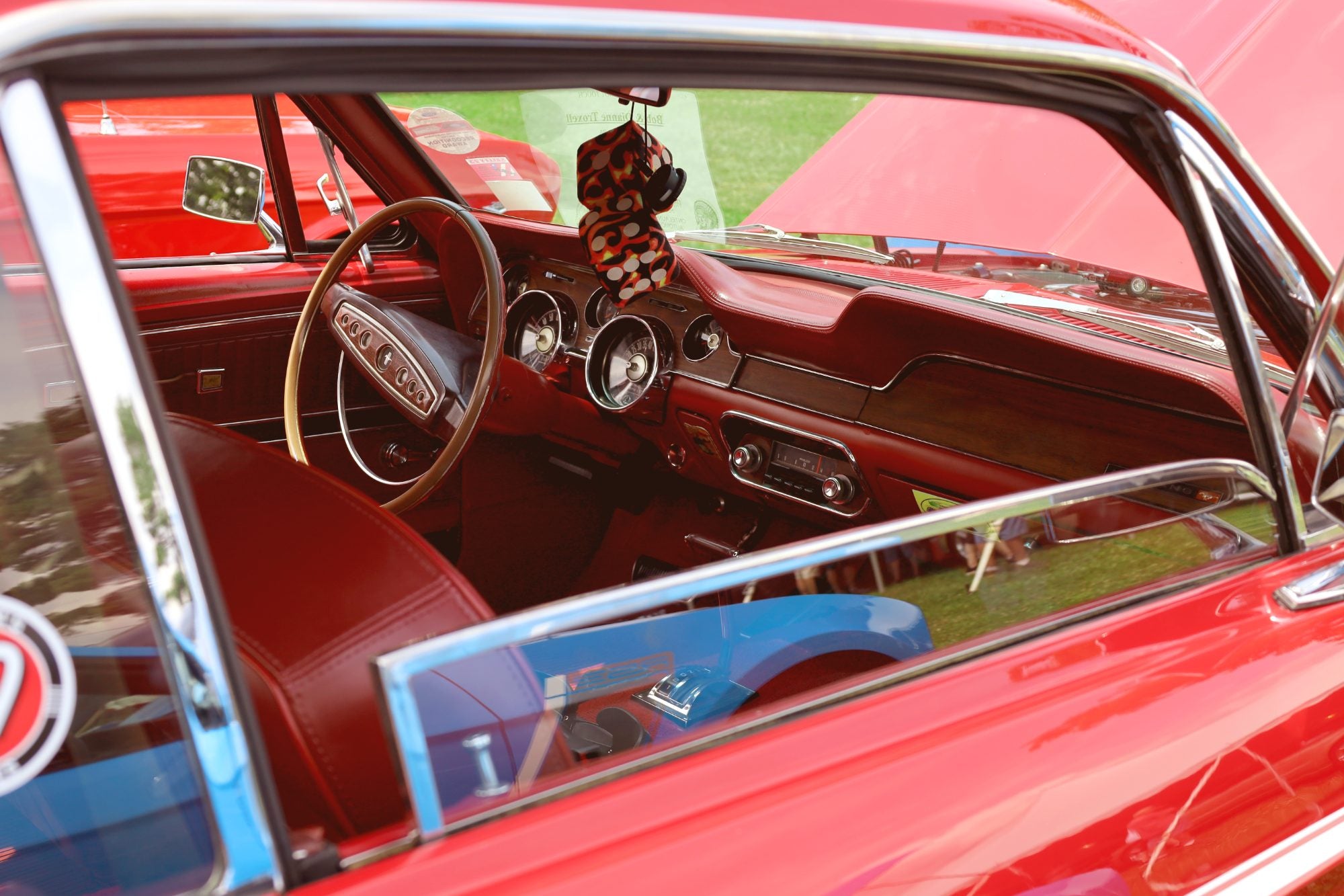 Red vintage car interior seen through the driver's window